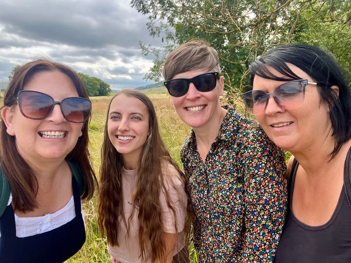 Four women in a park smiling at camera